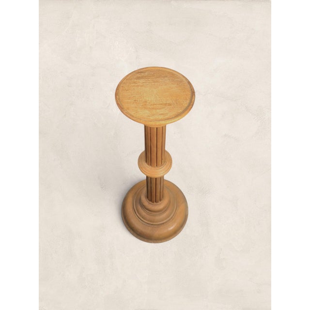 A beautifully turned English pine pedestal stand dating to circa 1970. Featuring a classic fluted column design and a...