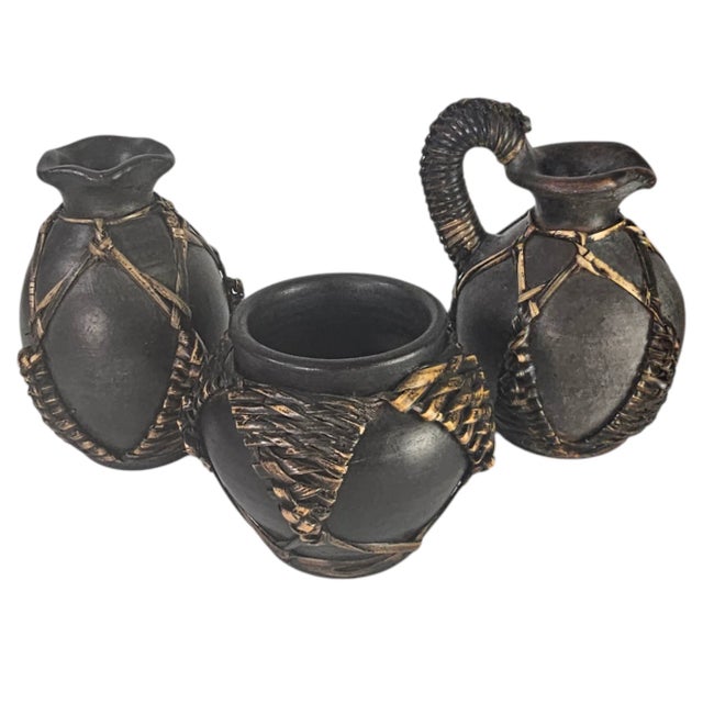 This vintage trio of earthenware vessels is distinguished by hand-applied wicker wrapping, a traditional African technique...