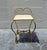 Elegant vintage vanity stool featuring a sculptural twisted gilt metal frame with graceful curves and a romantic heart...