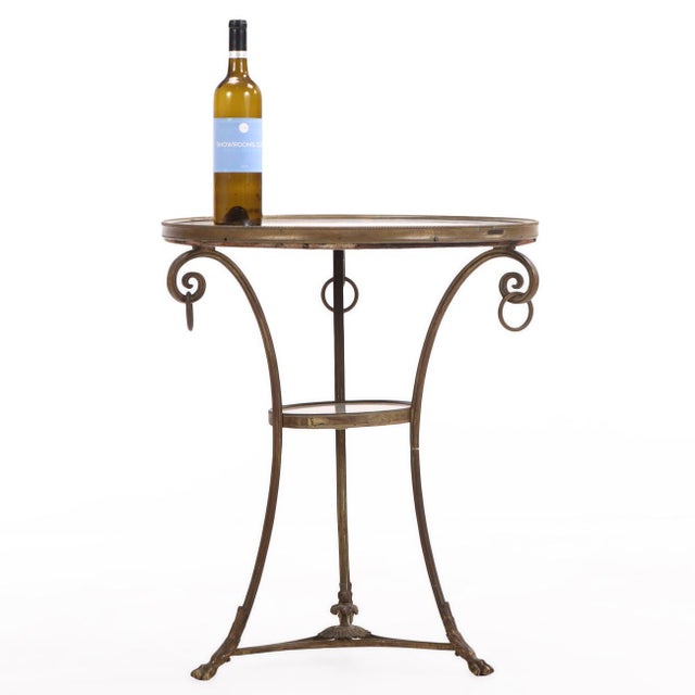This refined occasional table features a circular marble top resting within a finely crafted bronze frame with three legs...