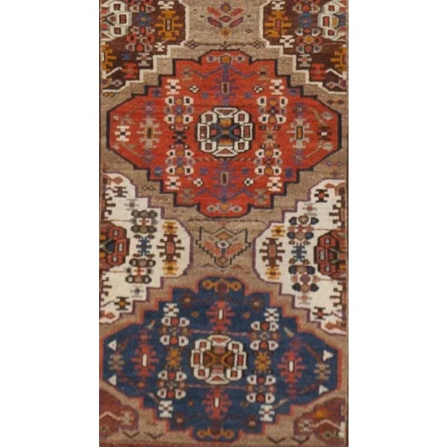 Offered is an impressive Antique Persian Kurdish runner, displaying an array of geometric medallions within triple guard...