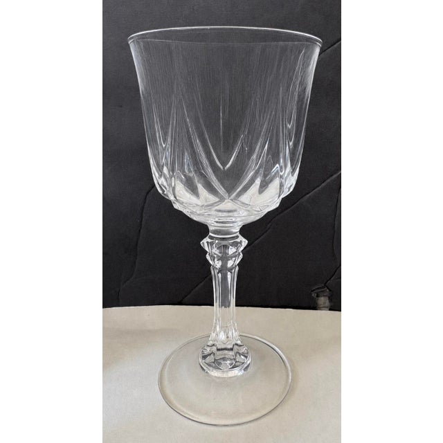 A refined set of eight vintage crystal-style goblets featuring geometric cut detailing and sculptural faceted stems. The...