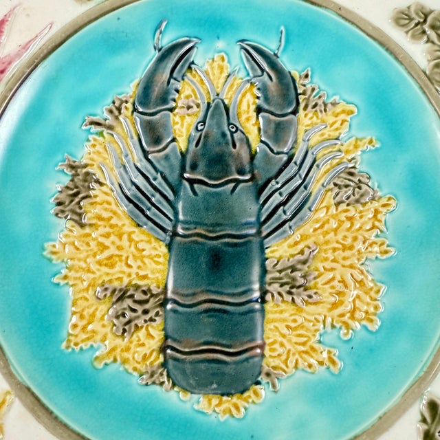 In the Aesthetic taste, a Wedgwood majolica sea food plate, showing a raised lobster on a bed of yellow and green seaweed...