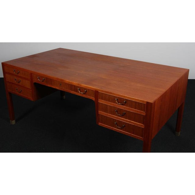 Ole wanscher for a. J. Iversen writing desk in teak. With handles and legs in brass. Made by a. J. Iversen in the 1950s...