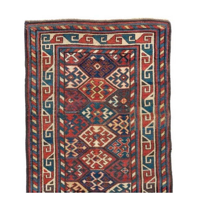 This is a hand knotted antique red ivory and navy blue tribal Caucasian Kazak rug, circa 1880-1900 measuring: 3 x 6 ft.