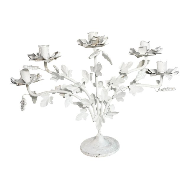 A vintage tole candelabra. Five arms covered in vine leaves and clusters of grapes. Each arm has a candle holder made of...