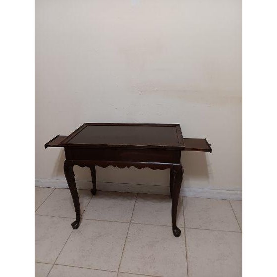Mahogany Queen Anne Style Tea Table Featuring Pull-Out Trays On Both Ends Style: Queen Anne Color: Mahogany Dimensions:...