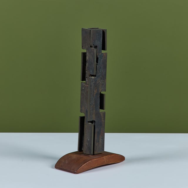 Bronze mounted abstract sculpture. The sculpture showcases an interlocking narrow bronze sculpture on a Douglas fir base....