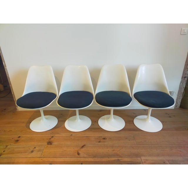 Four Saarinen Tulip swivel chairs. One is marked Knoll. Original navy blue fabric. 1970s edition. This piece has an...