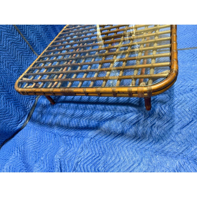 This vintage coffee table features a square design crafted from bamboo and rattan with a glass top, similar to mid-century...