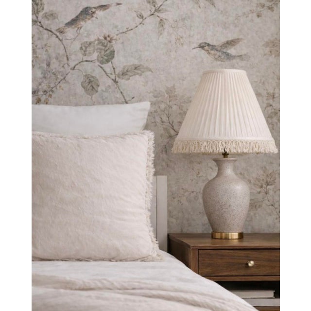 Mid-century ivory pleated empire lampshades with fringe, offered as a matching pair in a classic traditional silhouette.