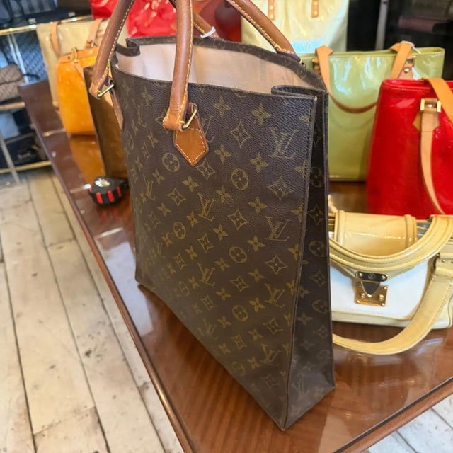 This timeless Louis Vuitton Sac Plat tote bag features the iconic brown Monogram coated canvas, instantly recognizable for...