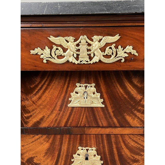 An elegant Empire period commode in solid mahogany and mahogany veneer, resting on column-shaped uprights with ringed...
