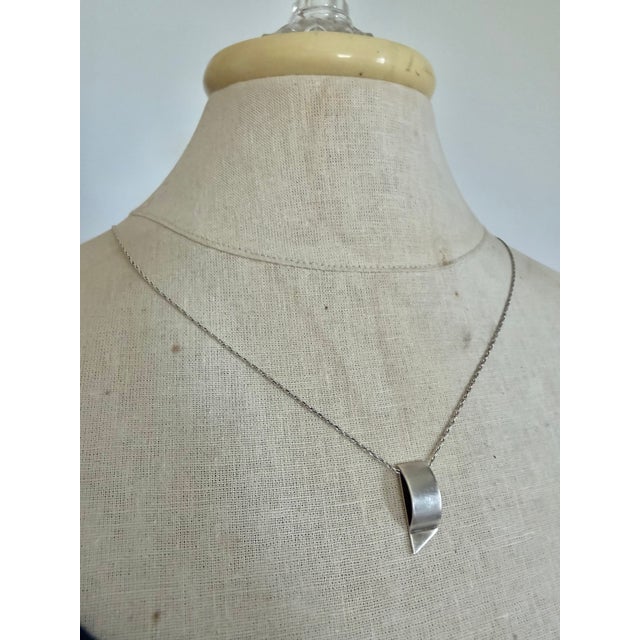 Contemporary Minimalist curved pendant on a fine matching chain. The polished sterling silver pendant is stamped "925",...