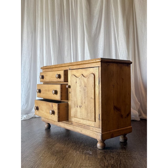 Description: This Early 20th Century pine dresser combines simple, timeless design with beautiful carved detailing. The...