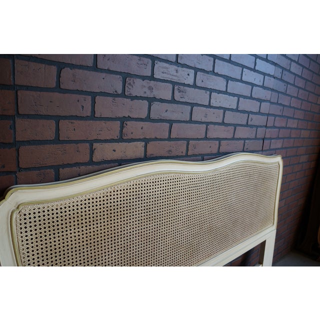 French Provincial headboard by Henredon. Featuring cane with a curvaceous wood trim. In original painted finish with glaze...