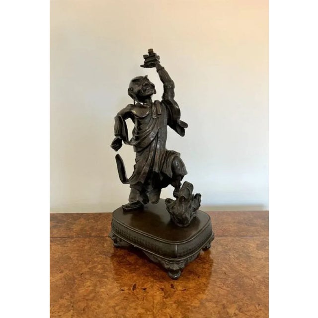 Quality large antique Japanese bronze figure having a quality large antique Japanese bronze figure of a man holding his...