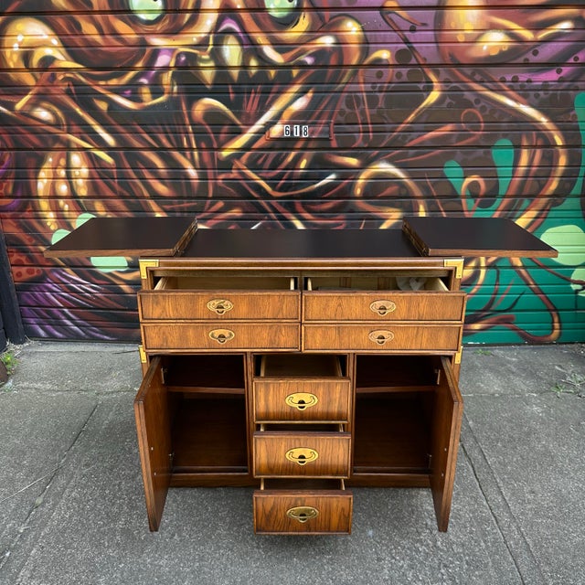 This vintage Lexington Campaign style dry bar has multiple storage compartments to optimize organization for service. The...