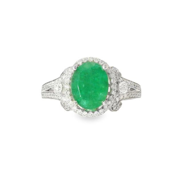 Beautiful estate cocktail ring crafted in 14K yellow gold, featuring a vibrant natural oval Colombian emerald surrounded...
