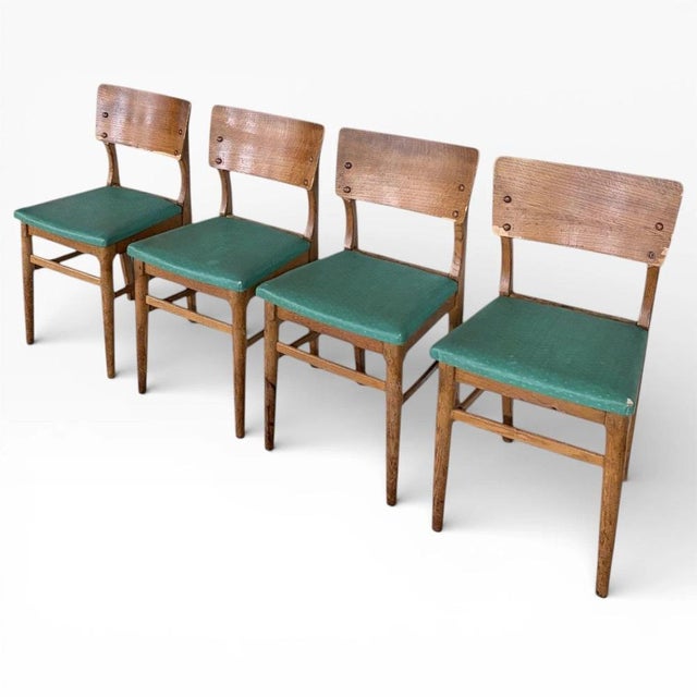 This set of vintage oak dining chairs combines solid oak craftsmanship with timeless style to enhance your dining space....