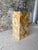 A striking antique pedestal clad in richly variegated golden stone, arranged in an expressive geometric mosaic pattern....