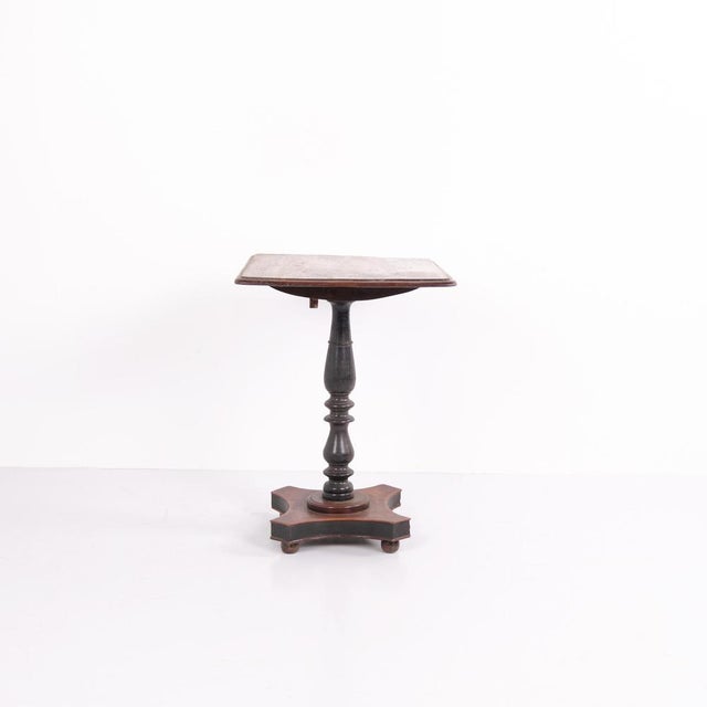 Antique pedestal side table from the 1890s, made of oak. The table stands on a central pedestal base and features a tilt-...