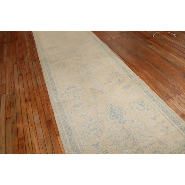 a 1920s turkish oushak runner with a soft creamy beige field, accents in sfot blue and green Measures: 3'8'' x 21'6''.