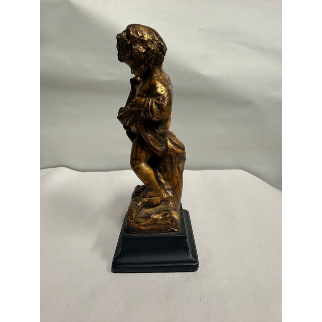 This vintage Borghese cherub statue features a detailed gold-tone finish and stands approximately 7 inches tall. It is...