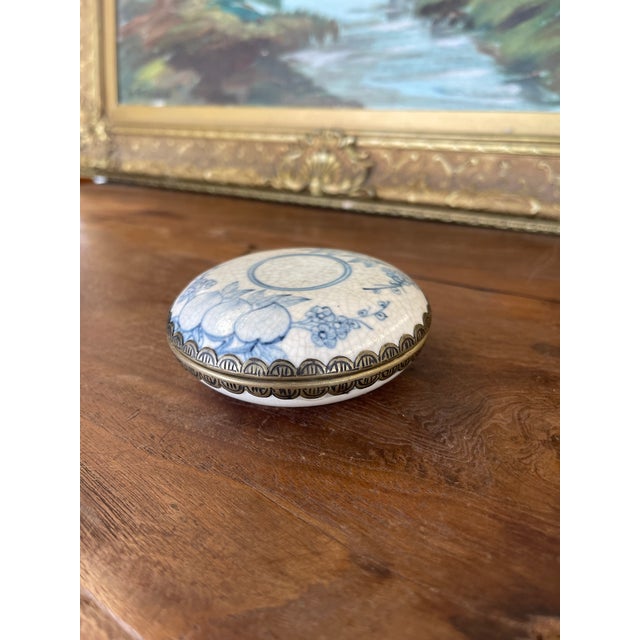 This believed to be antique Chinese porcelain lidded box features classic blue and white hand-painted decoration with a...