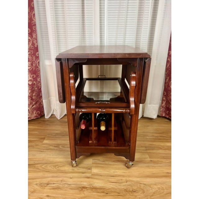 Elegant early 20th-century mahogany serving trolley, circa 1910–1925, featuring a rectangular drop-leaf top and a...