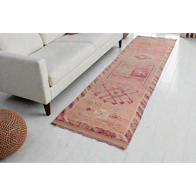 This is a vintage Turkish Oushak rug from the Mid 20th Century. The piece was hand-knotted.