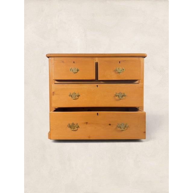 This antique English pine chest of drawers brings warmth, character, and practical storage to a collected interior....