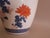 Hand-painted vase from China with orange and blue floral motif. Crackle cream glaze backdrop. Blue painted border at...