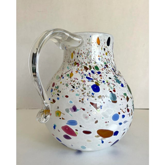 This signed studio art glass pitcher, dated 2009 and attributed to glass artist Josh Gelfand, features a beautifully...