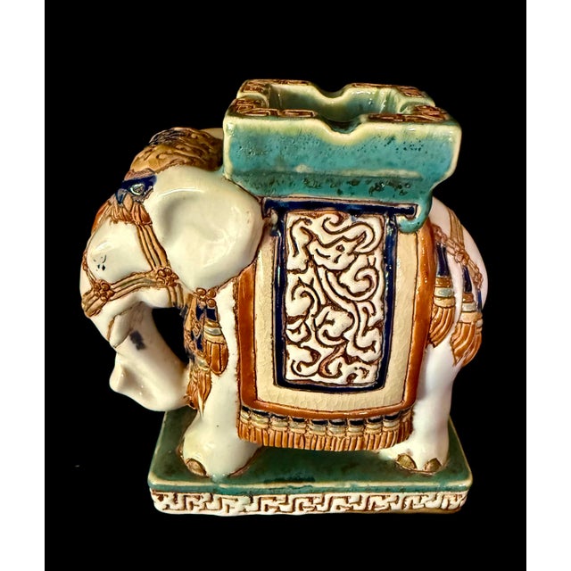 The elephant pictured features ornate decorative harness details and sit on a rectangular base, serving as both a...