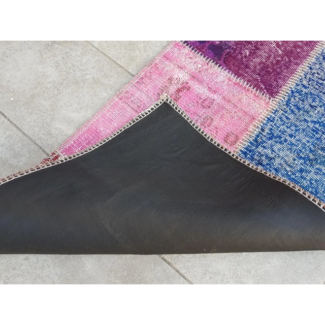 This is a vintage Turkish Oushak rug from the Mid 20th Century. The piece was hand-knotted.