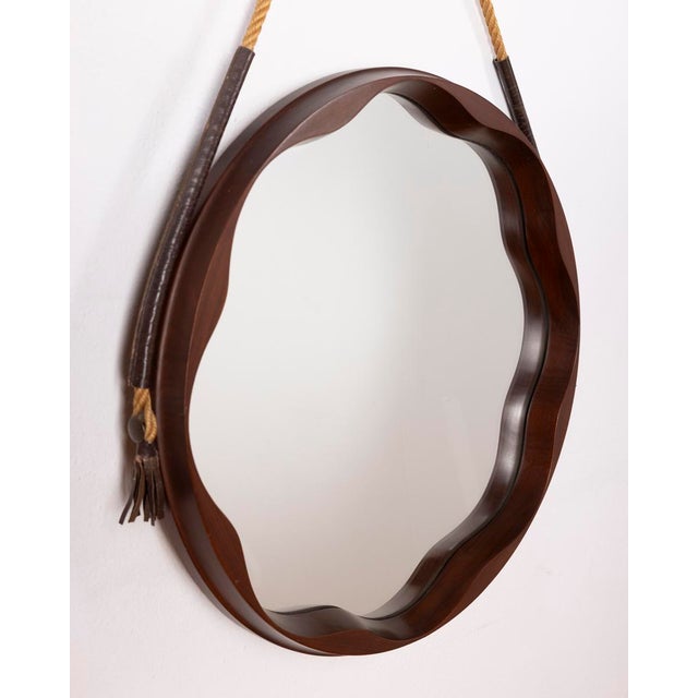 Wall mirror with cord for hanging it on the wall, round frame in shaped walnut wood, Italian design.