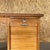 1920s small compact French tambour desk featuring a warm, honey-toned natural wood finish. The piece is designed with a...