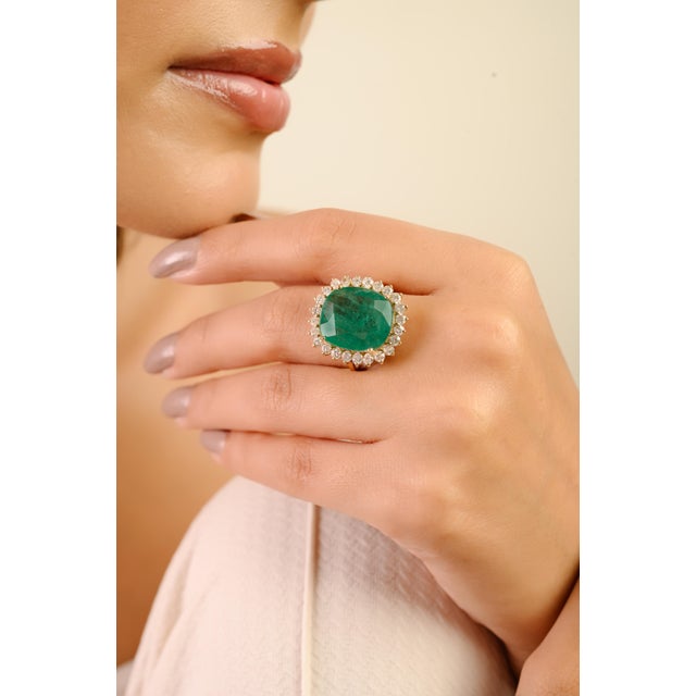 This luxury ring features a large, oval-cut emerald as the center stone, estimated to weigh 9.17 carats, surrounded by a...