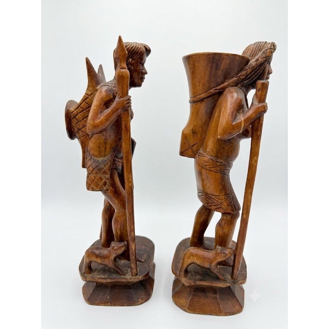 This is an exceptional, highly detailed pair of vintage mid-century hand-carved wooden folk art statues depicting the...
