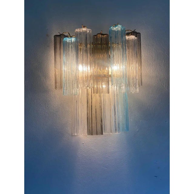 A pair of contemporary“tronchi” wall sconce. two levels of light- blue, trasparent and grey “tronchi” murano glass hand-...