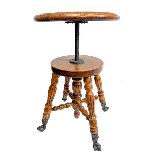 Antique, victorian adjustable piano stool - made in America. It is solid wood and features four beautiful iron ornate...
