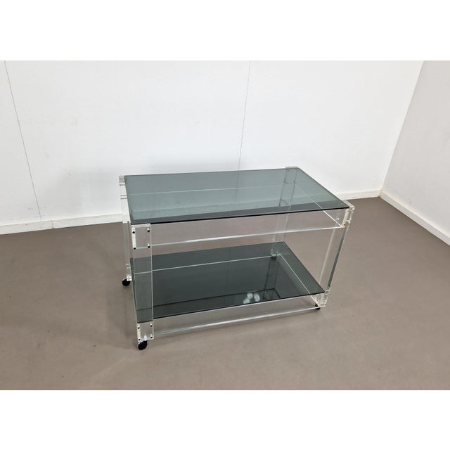 This trolley sure has some good looks with its transparant base of acrylic glass and two smokey grey glass tiers. Suits...