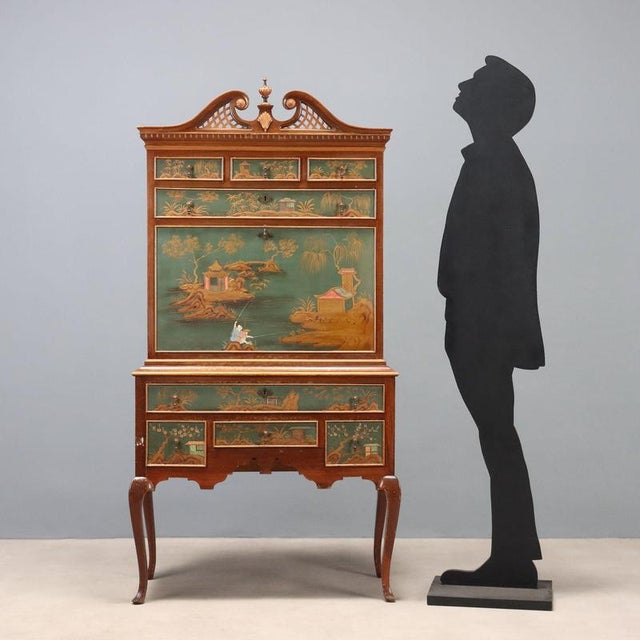 Chinoiserie-style mahogany cabinet, partially lacquered and painted. Carved cornice, front with eight drawers and a drop-...