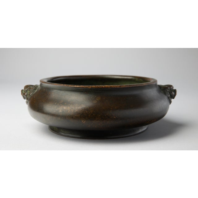 A well-cast Chinese bronze censer of compressed globular form, raised on a low foot ring and fitted with a pair of finely...