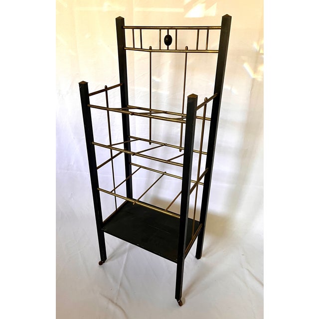 1930/40s art deco style magazine stand. Sleek black wood contrasts with brass finishes. Four shelves - two slanted and two...