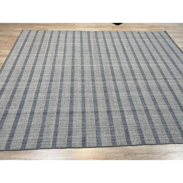 A hand-knotted wool rug, made in India and measuring 4' x 6'. Geometric drawing - repeating motifs held inside strong...