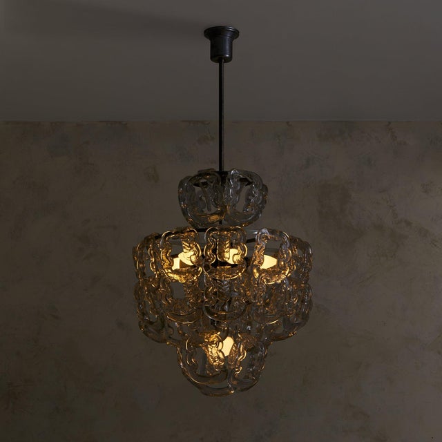 A luminous cascade of interlocked Murano glass, this Italian chandelier is attributed to Angelo Mangiarotti for Vistosi,...