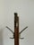 A clean, minimalist solid‑wood coat rack featuring a tall turned post, two metal double hooks, and a sturdy cross‑base....