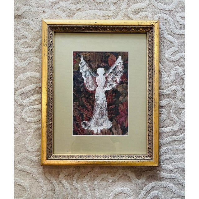 Framed angel art by noted folk art/outsider artistAnnie Wellborn (American, 1928-2010). White paint atop floral tapestry;...